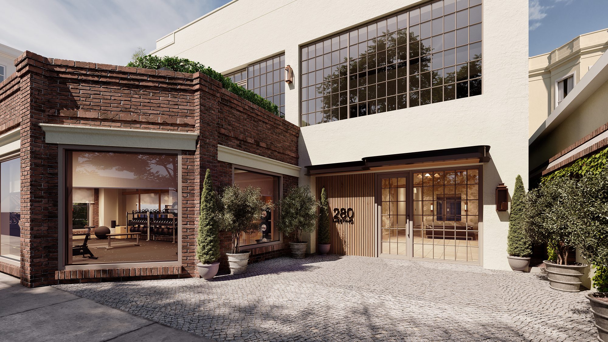Courtyard-side resident entry with gym storefront, steel windows, and cobblestone drive